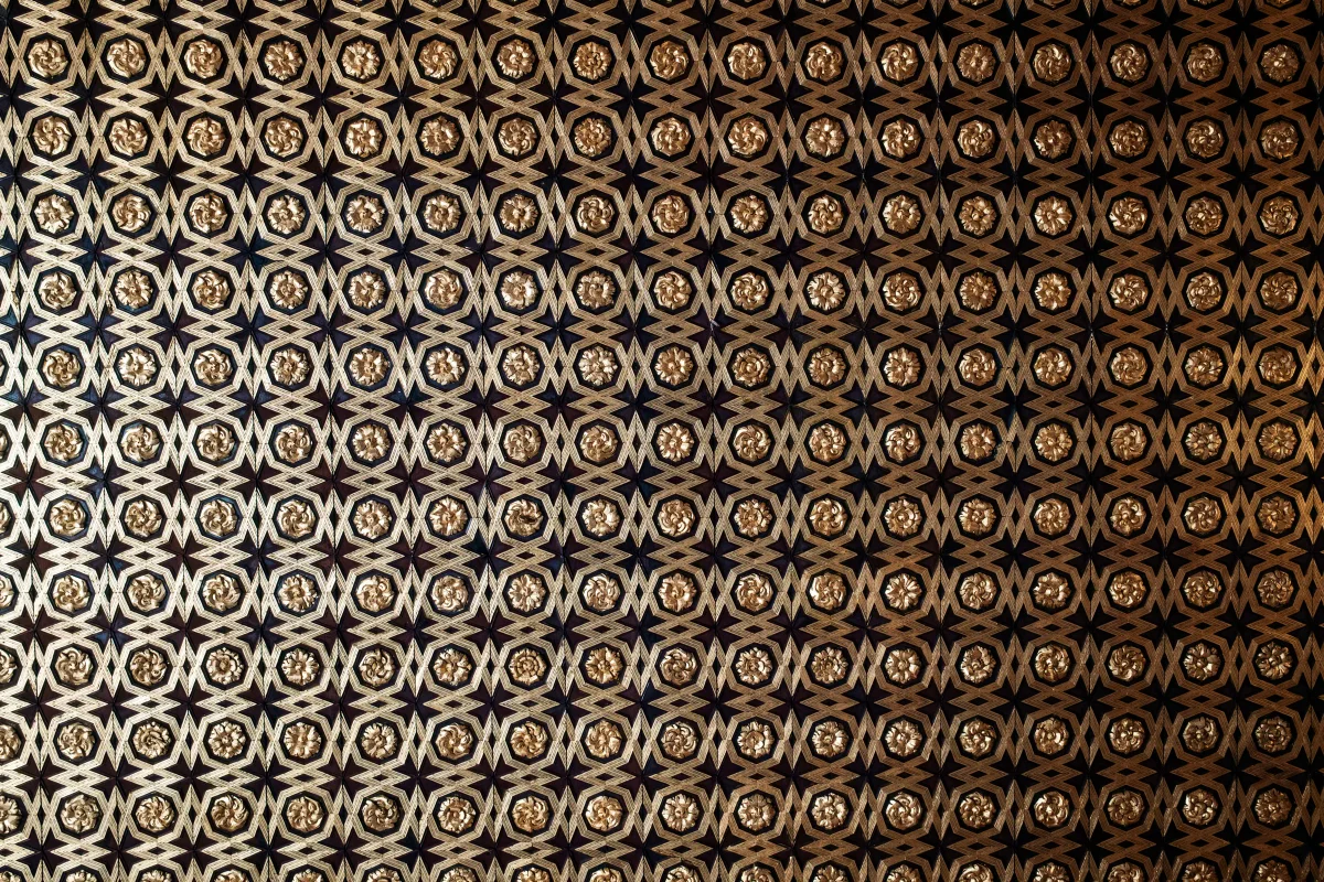 Gilded geometric star pattern covering a Moorish-style ceiling