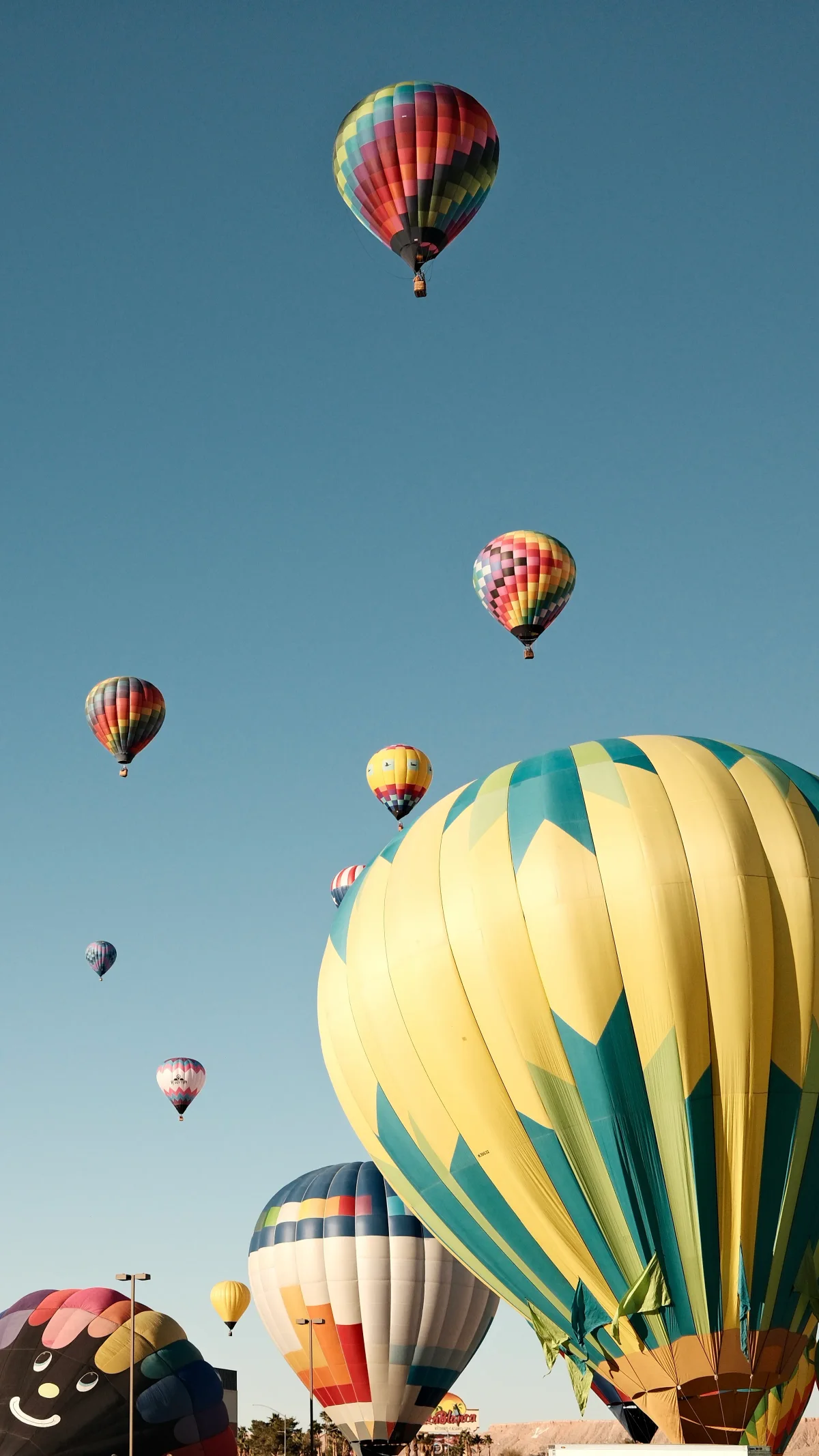 Dozens of hot air balloons rising into a blue sky at the Mesquite, Nevada balloon festival