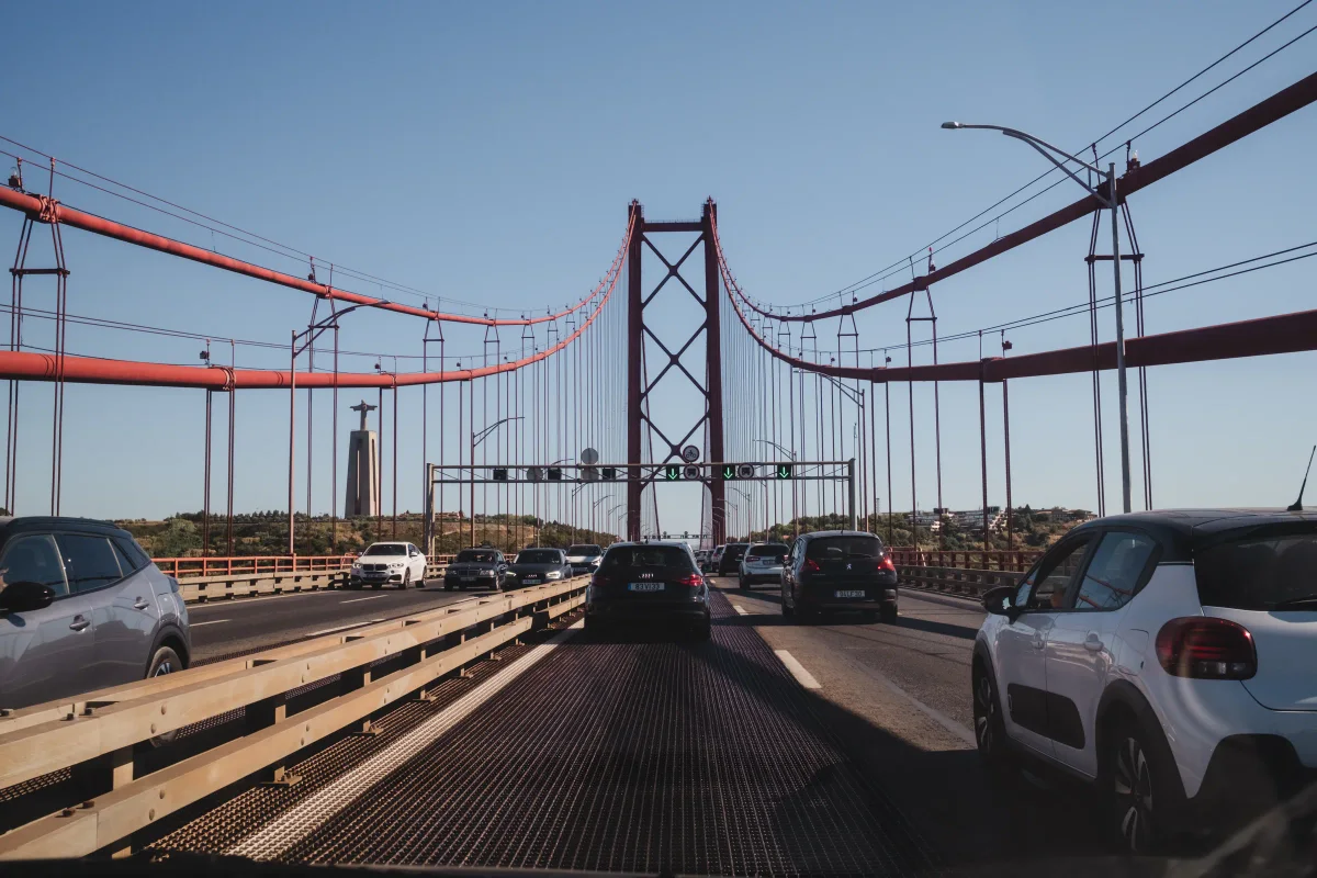 Driving across the 25 de Abril Bridge in Lisbon with Cristo Rei in the distance