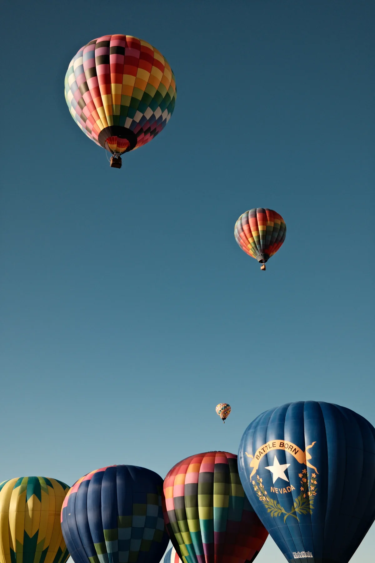 Battle Born Nevada balloon rising with colorful balloons at the Mesquite, Nevada balloon festival