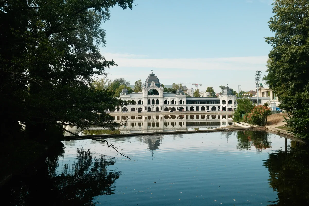 White domed building reflected in a still lake framed by dark trees