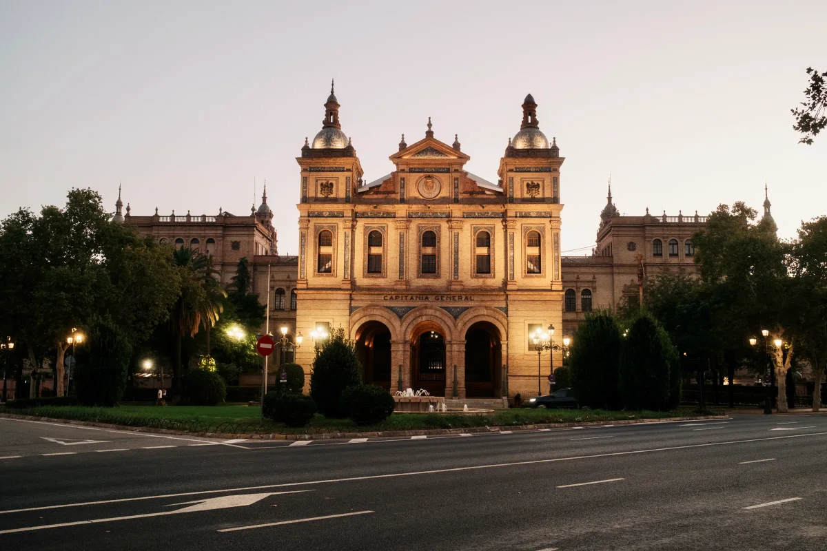 Capitanía General building lit at dusk in Seville's Plaza de España