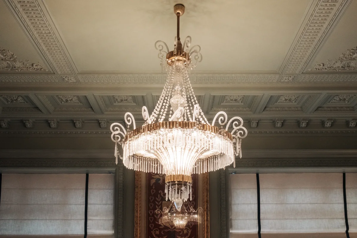 Crystal chandelier hanging from an ornate plaster ceiling