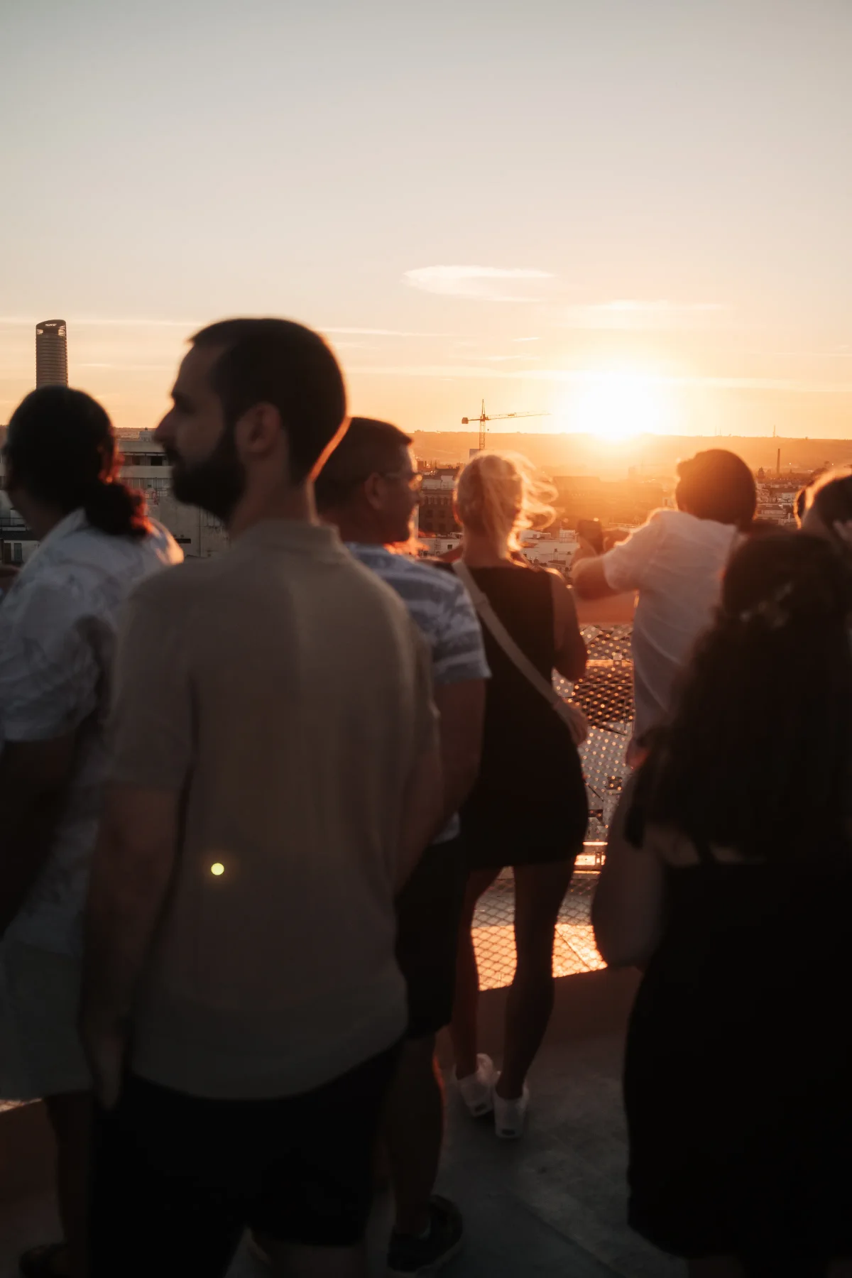 Crowd watching the sunset from a rooftop walkway over Seville
