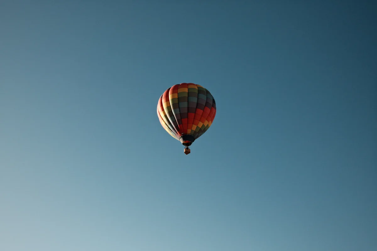 Single striped hot air balloon in an empty blue sky over Mesquite, Nevada