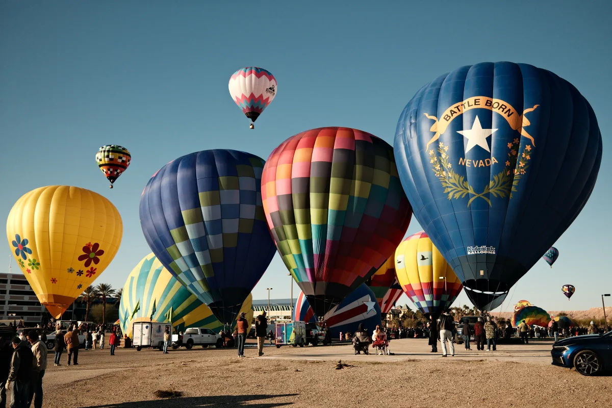 Crowd among inflated hot air balloons including Battle Born Nevada at the Mesquite balloon festival