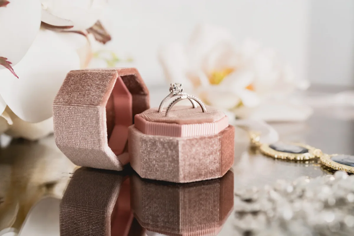 Close-up of a diamond engagement ring in an open pink velvet box